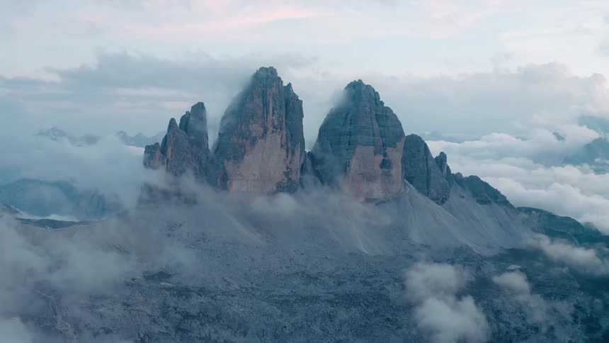 Red tints clouds filling sky over foggy shrouded mountain