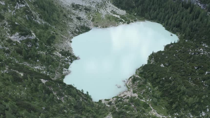 Aerial panorama of a white lake and reflecting sky with mountains and forests around
