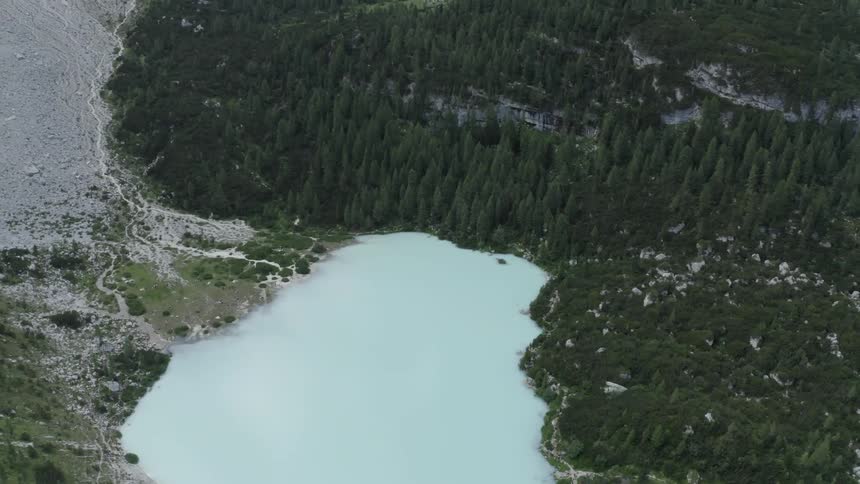 Aerial scenery of a white lake surrounded by forests hills and mountains