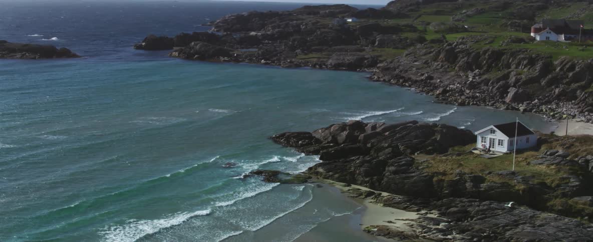 Houses sit on a rocky coastline