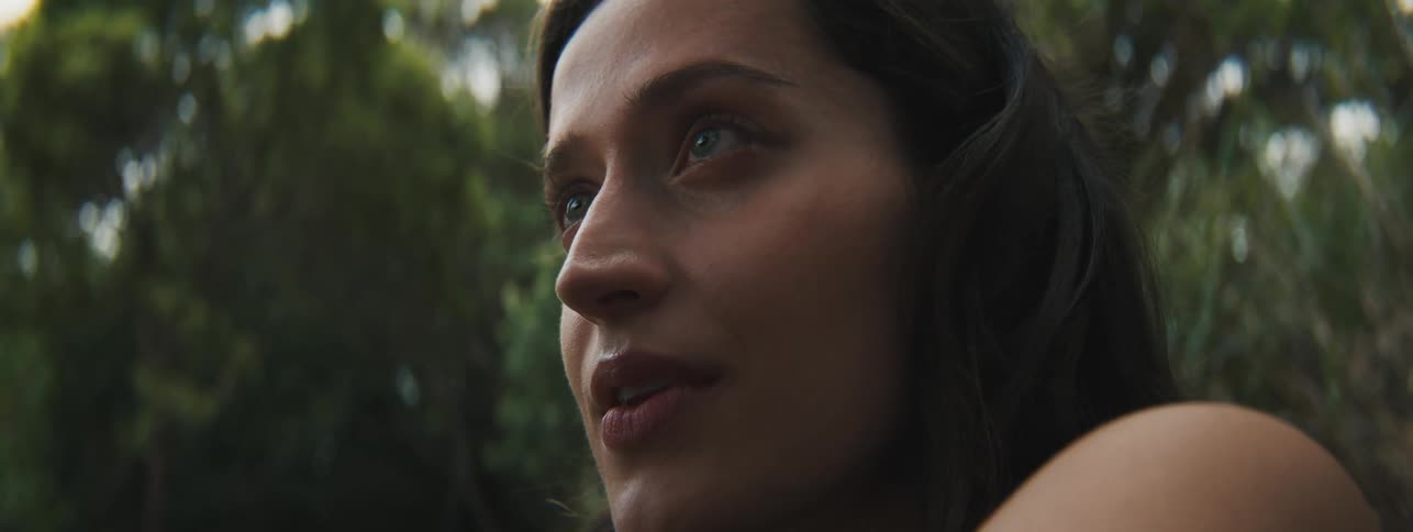 A woman looks at something shes holding up and smiles