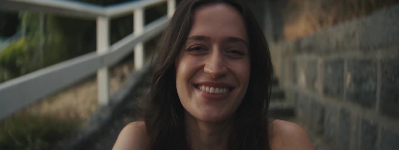 Portrait of a smiling young woman sitting on stairs in an outdoor environment