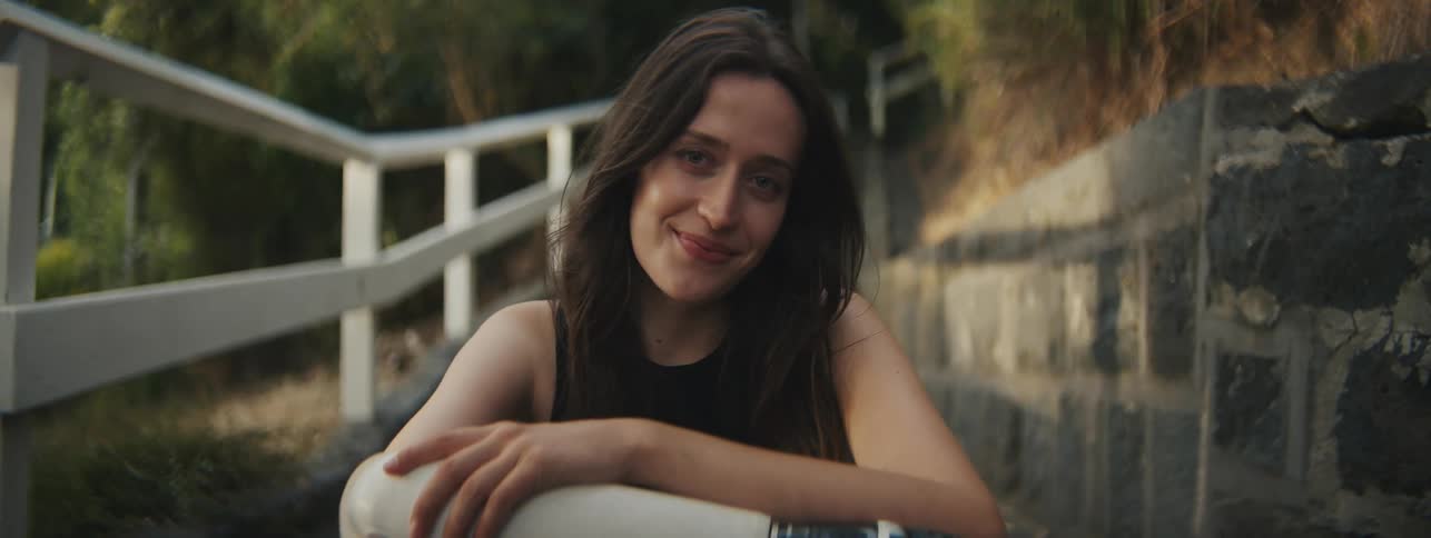 A woman with a mechanical arm sitting outdoors