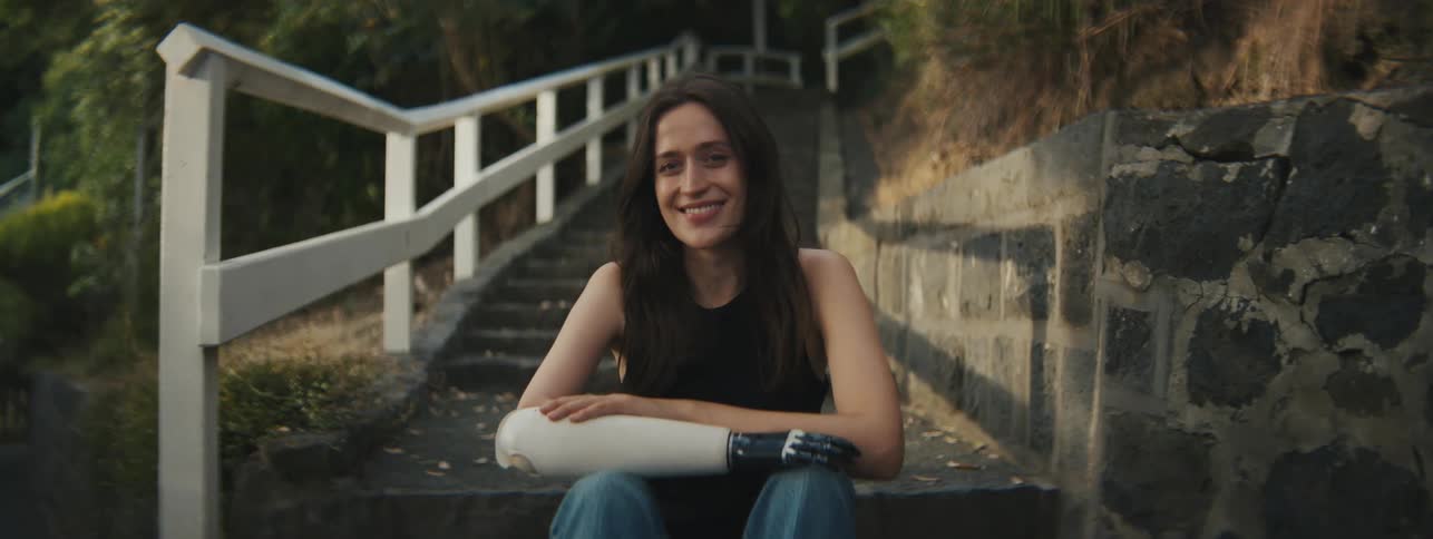 A woman sitting on the steps of an external staircase