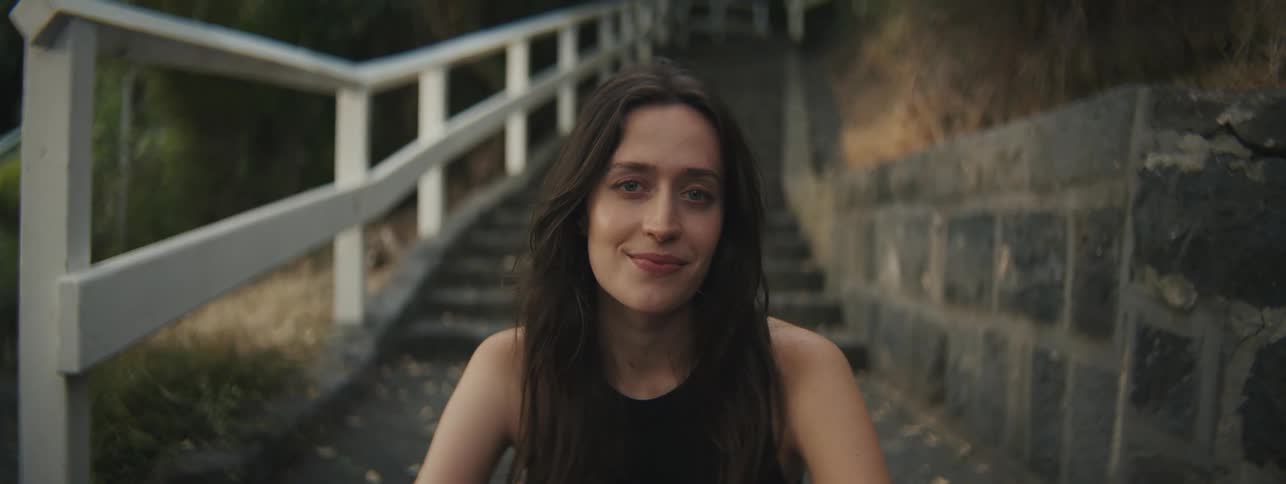 Lady smiling while seated on the stairs outdoor at night