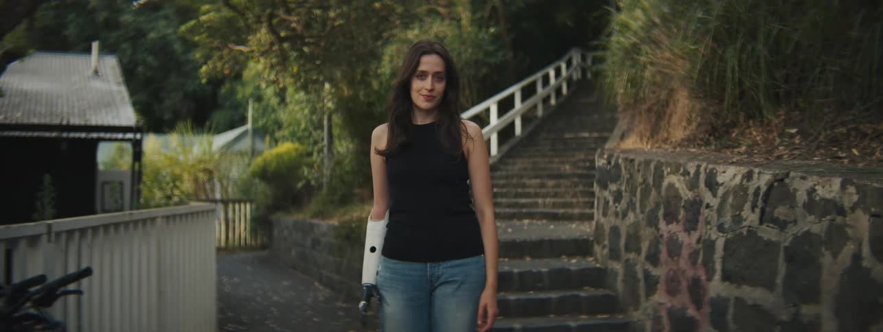 Young woman in an outdoor environment in a residential neighborhood with vegetation and with one of her hands is a mechanic