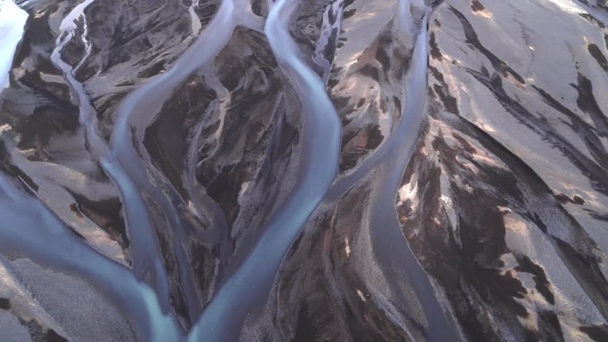 Aerial view of glaciar rivers flowing on a dark landscape