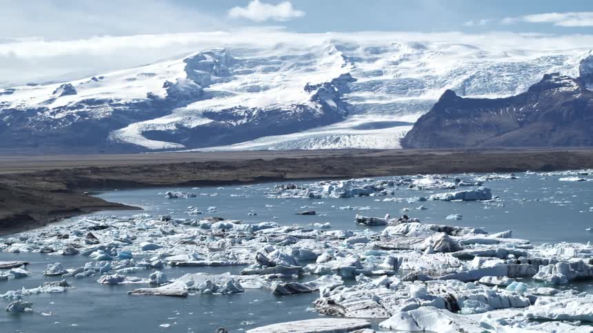 Ice floats all over the water by the mountains