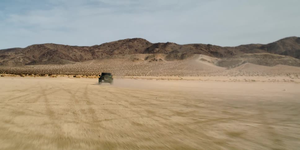 Truck drives through the desert toward the mountains