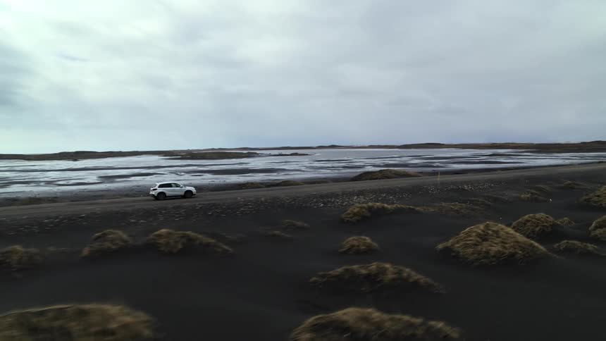 Car drives on a wet road near the beach
