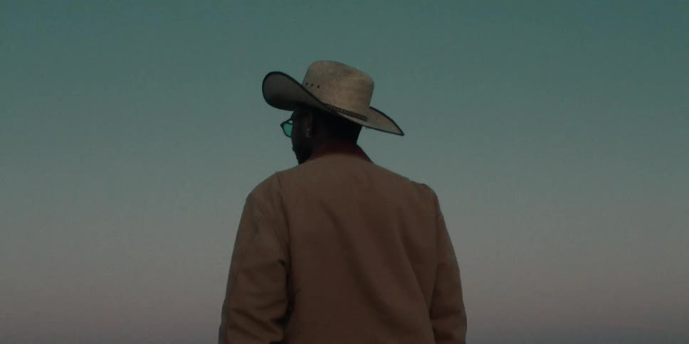 A man is watching the sunset on the beach
