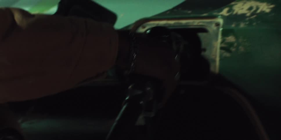 Close up of a hand grabbing a gas pump nozzle placed on a vehicle