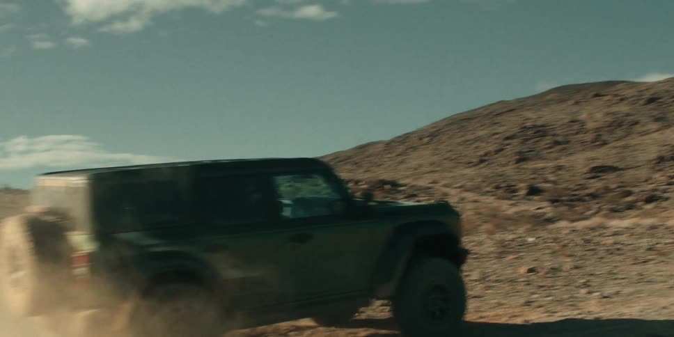 Car driving off road through a desert on a sunny day