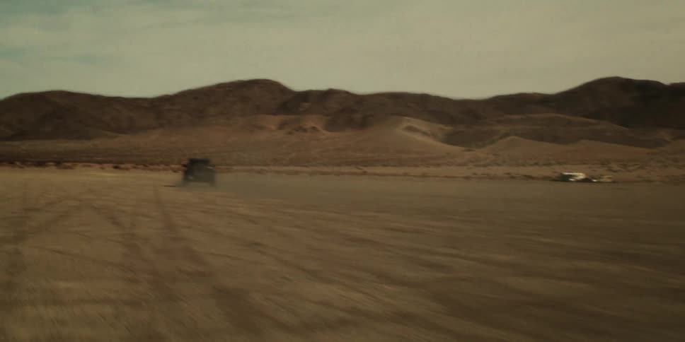 A truck race through the desert towards the mountain