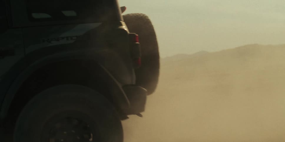 A vehicle drives across a desert