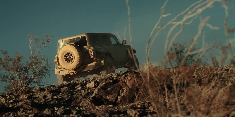The truck is driving off road climbing up the hill