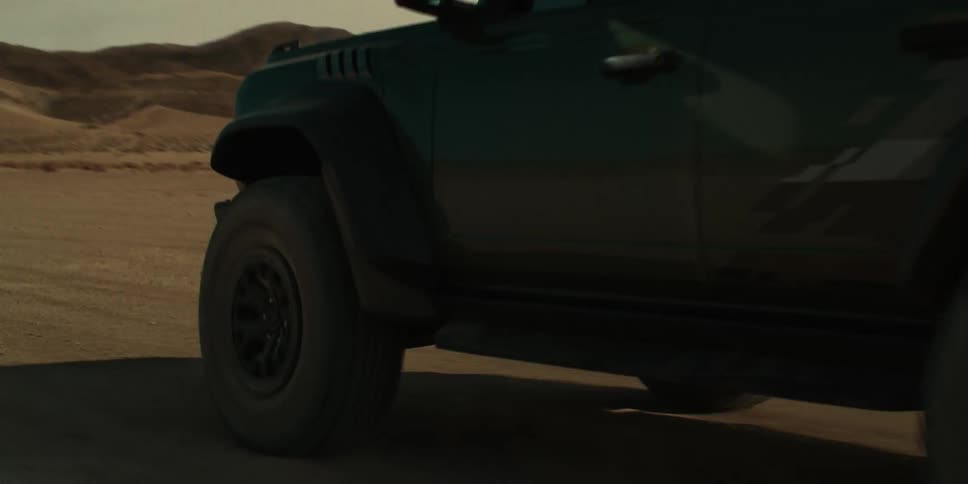 Jeep traveling on a dirt road in a natural environment with mountains around