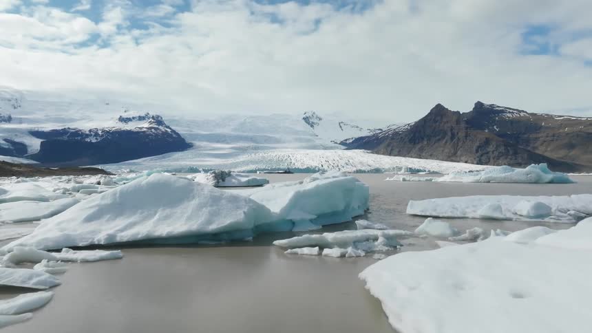 Aerial view of icebergs floating next to a glacier