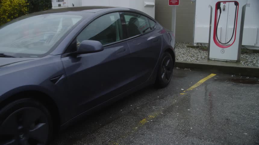 A person parks their electric car at a charging station