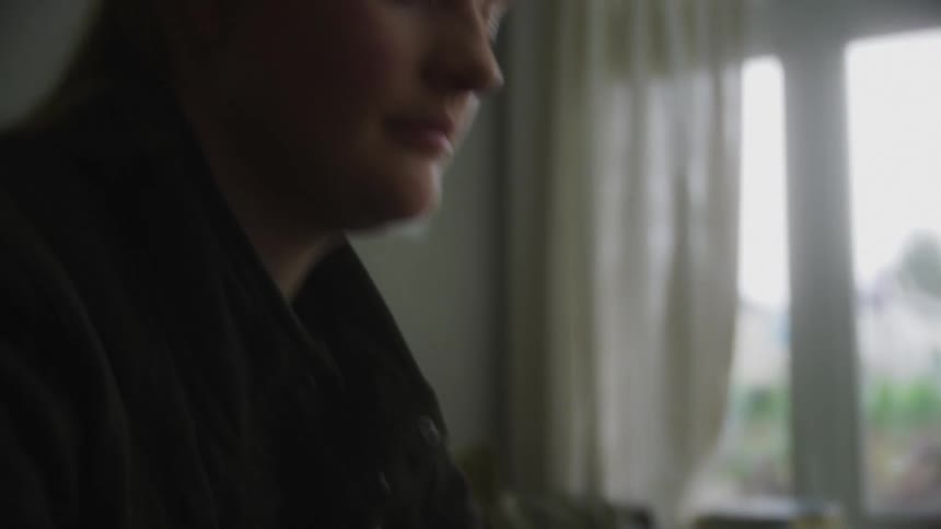 Portrait of a young woman sitting at a table and typing on her laptop