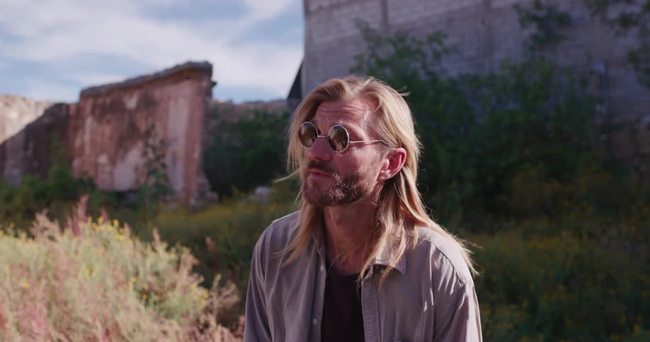 Man nods while standing in front of crumbling walls