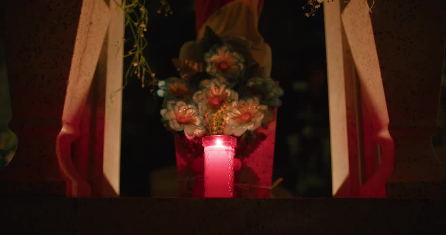 A candle sits on the gravestone