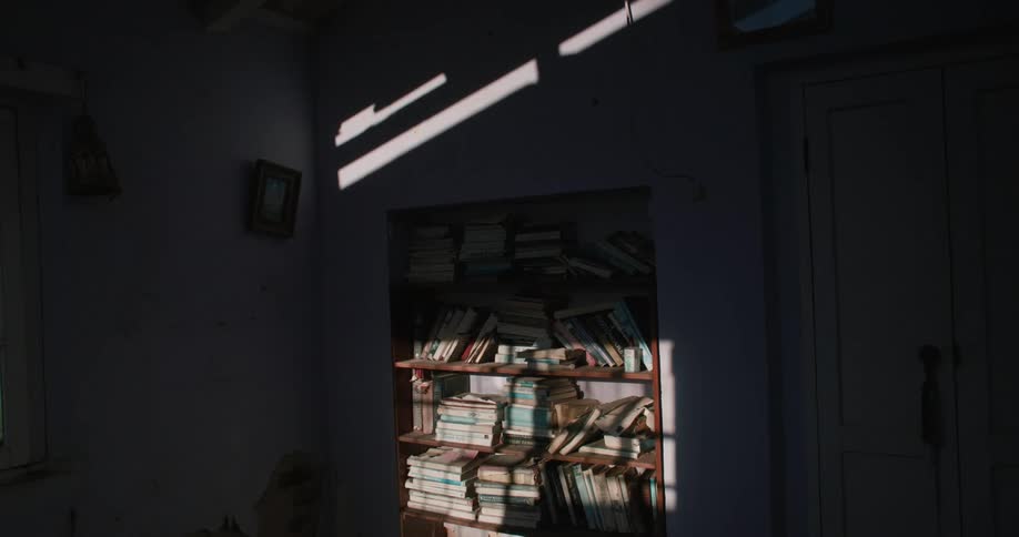 A bookcase filled with books inside a dimly lit room