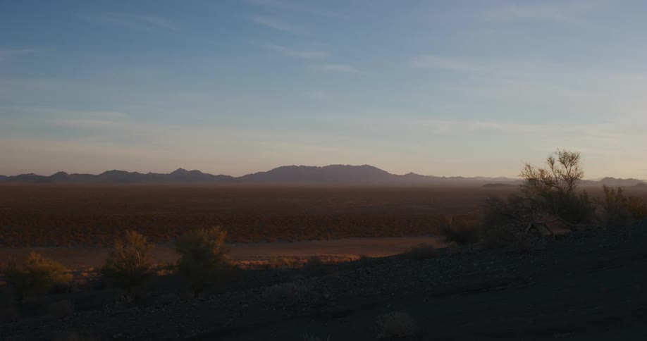 A vast plain gives way to distant mountains