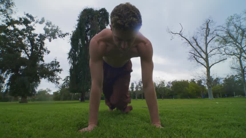 A man is exercising on the grass