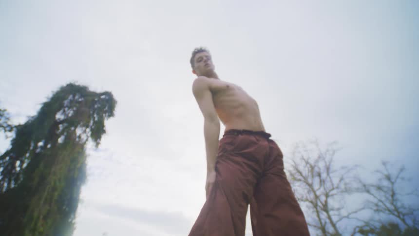 Man is jumping and dancing outdoors on a sunny day