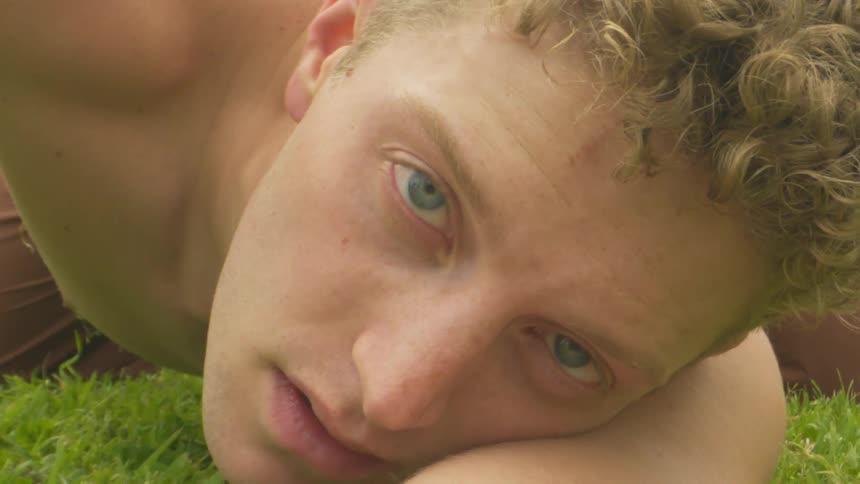 Man is resting his head on the grass during spring season