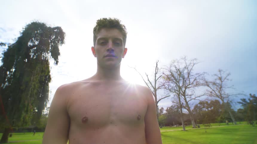 Portrait of a young shirtless man in a natural park