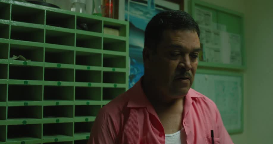 A man working in an office has a conversation with someone