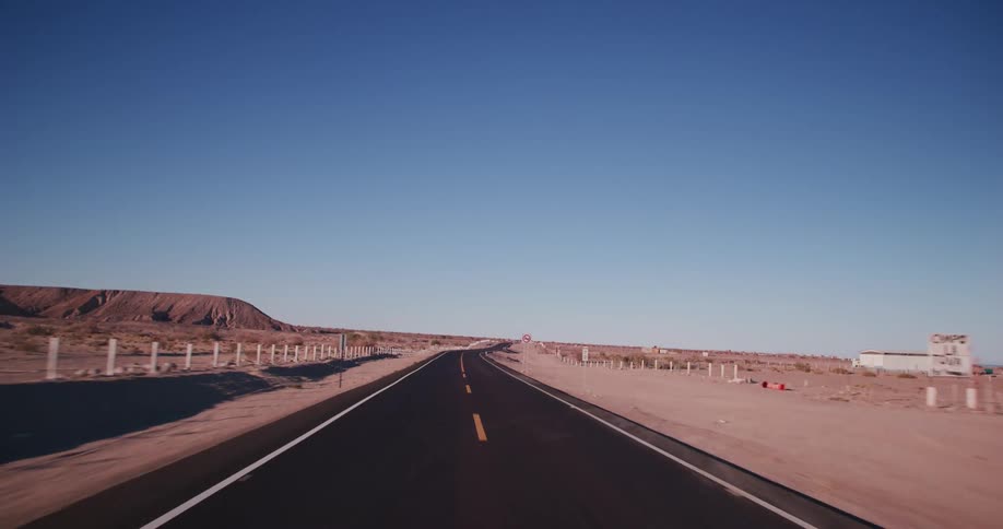 A highway in a rural deserted landscape on a clear sky day