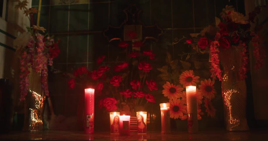 Flowers and burning religious candles inside a home