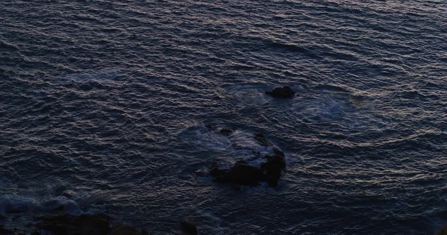 Waves crash into rocks along a shoreline