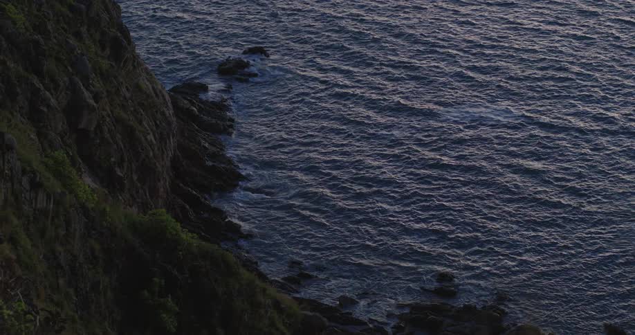 View down to the ocean with calm waters at the edge of the sea coast