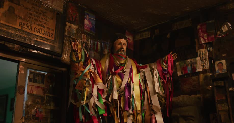 Large statue covered in ribbons is standing in a cluttered room