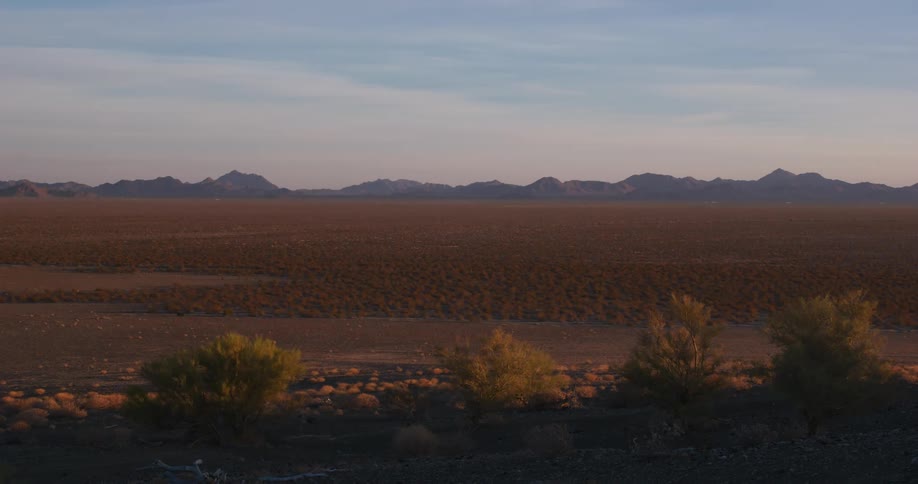 Sun is setting above the desert landscape with little plant life
