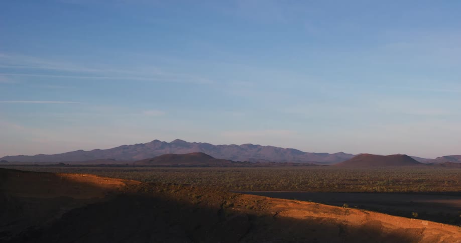 Shallow lake in front of a field and mountain range