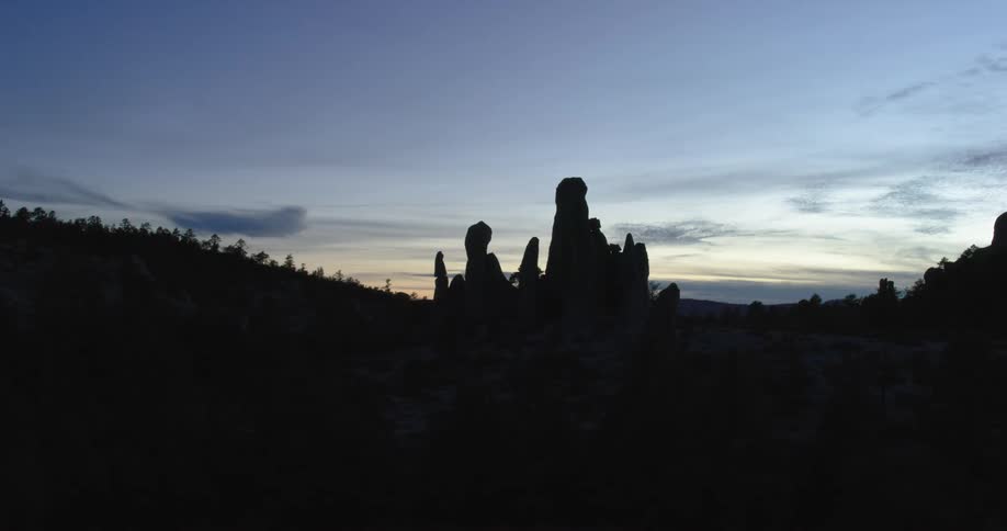 Rocky mountain silhouette with vegetation on a dawn sky day
