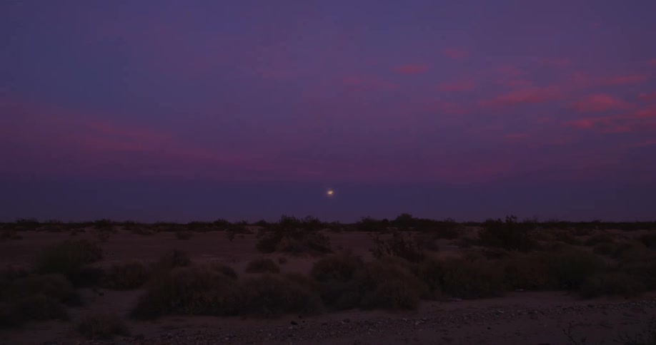 The sun is setting on the desert