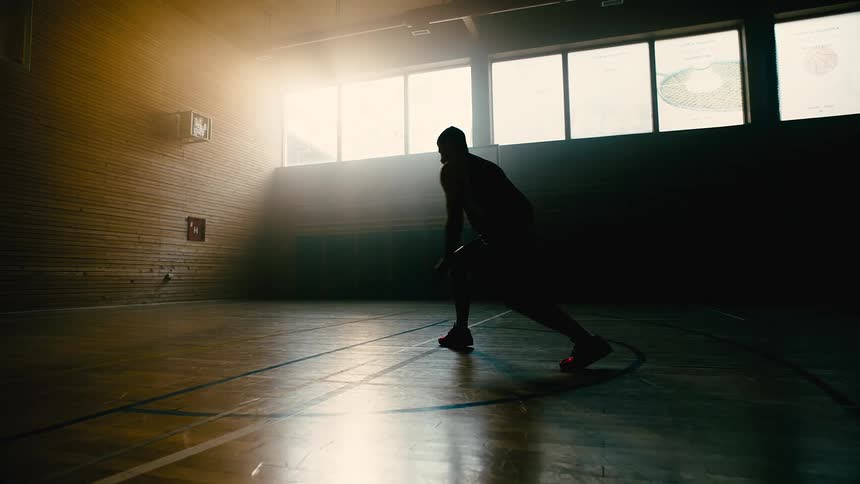 Man practicing basketball shots on a court