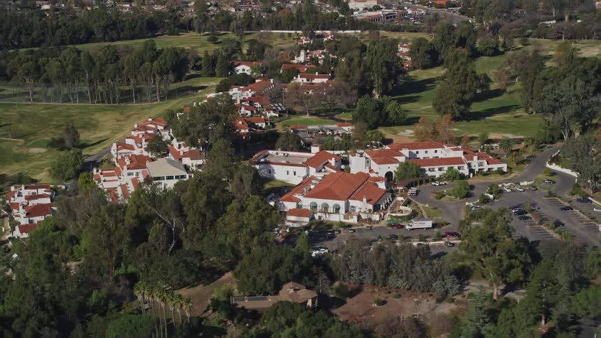 A helicopter films a large resort with nearby houses