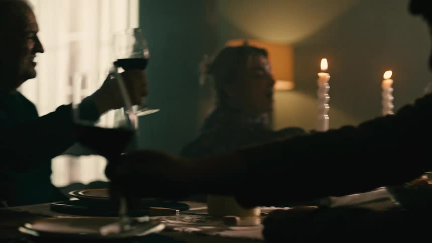 Friends gathered at a table cheering with wine glasses before eating