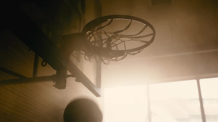 Basketball falling into a basket on an indoor court