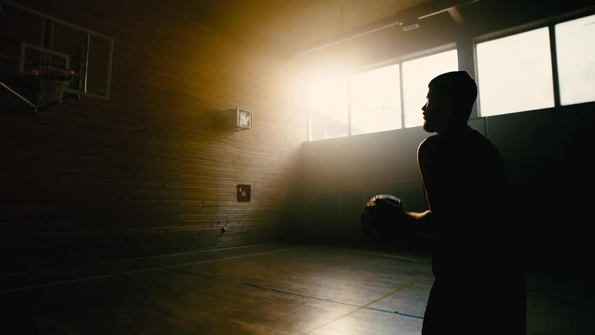 A man shoots a basketball into a hoop