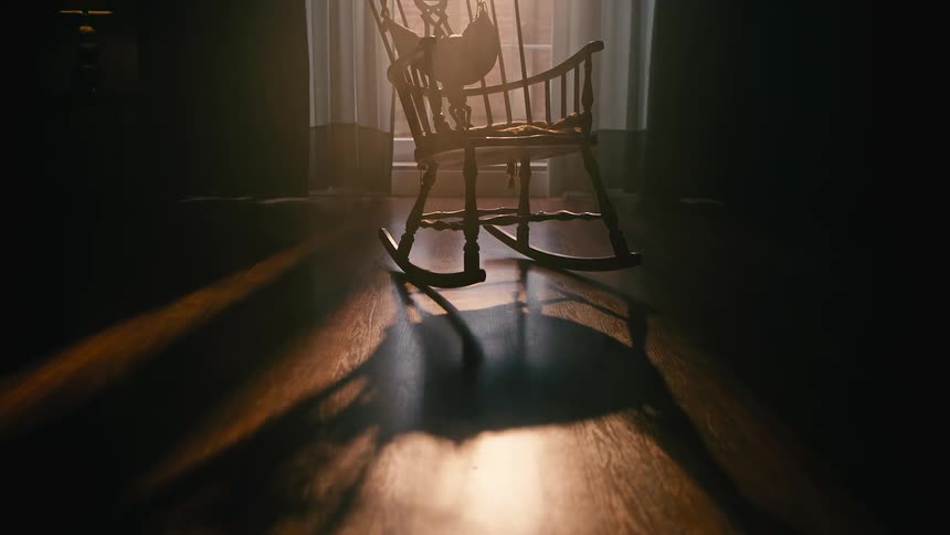 Wooden chair swinging in a room with natural sunlight reflection