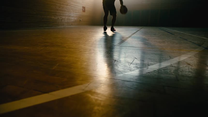 Man on a basketball court training with the ball