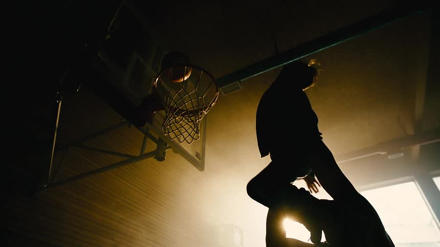 A father lifts is son up to shoot a basketball